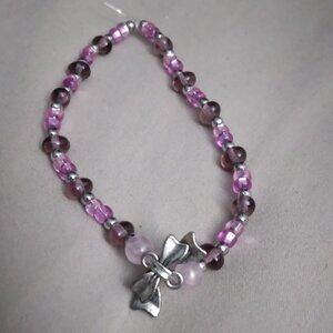 Pink beaded stretchy bracelet with silver bow detail
